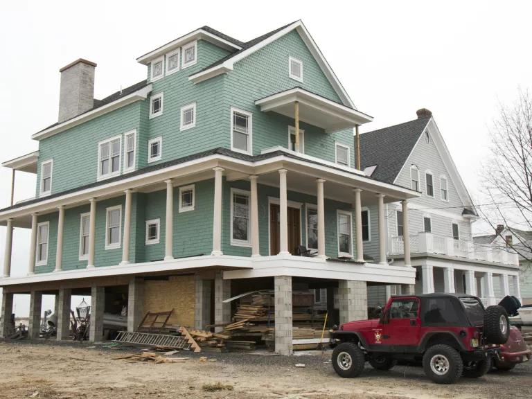 A house near a waterway is raised on stilts