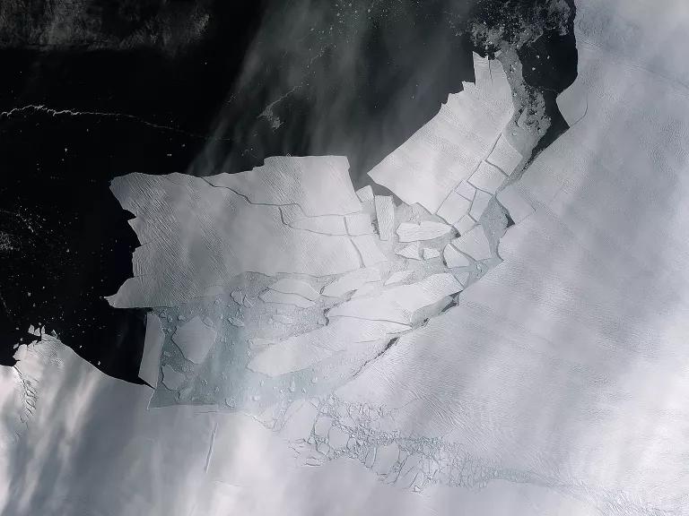 An aerial view of an iceberg with many cracks in it